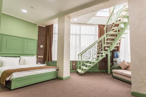 a bedroom with a bed and a spiral staircase at Grand Sapphire Hotel in Almaty