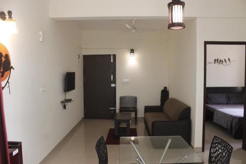 - un salon avec un canapé et un lit dans l'établissement Tranquil Serviced Apartments, à Bangalore