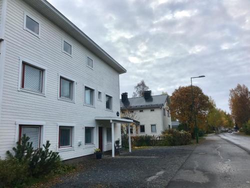 - un bâtiment blanc avec une rue en face dans l'établissement E-City B&B, à Tornio