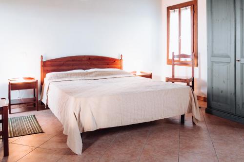 a bedroom with a large bed with a wooden headboard at Agriturismo Cà Vendramin in Ca Vendramin