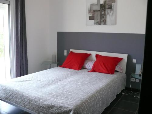 レザルク・シュル・アルジャンにあるLes Karakisのベッドルーム1室(大型ベッド1台、赤い枕付)
