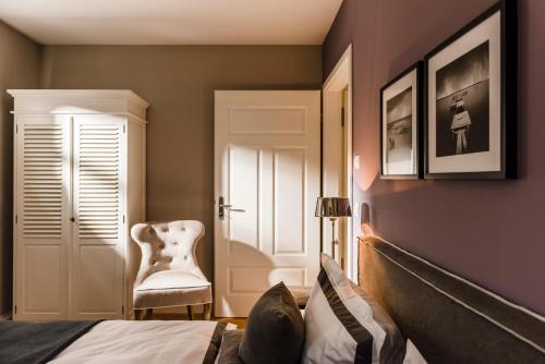 a bedroom with a bed and a chair at Kamphof Usedom Ferienanlage in Loddin