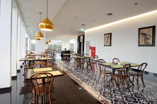 a restaurant with tables and chairs in a room at Malioboro Prime Hotel in Yogyakarta