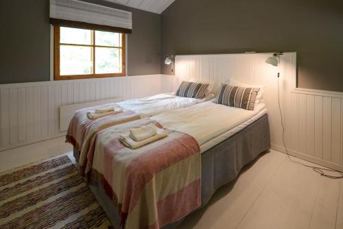 a bedroom with a large bed with two towels on it at Sahanlahti Resort in Puumala