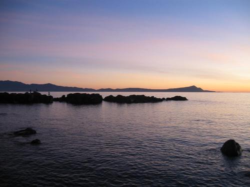 a group of rocks in the water at sunset at Hotel Quintas Papagayo in Ensenada