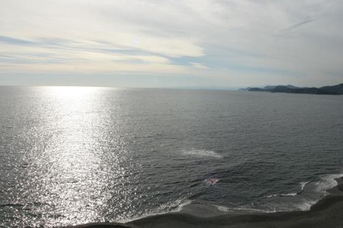 a large body of water with the sun reflecting on it at Tabinoyado Ushionoakari Geiboso in Shima