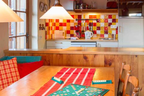 a kitchen with a wooden table and a kitchen counters at Chalet Il fera beau demain in Villard-Reculas