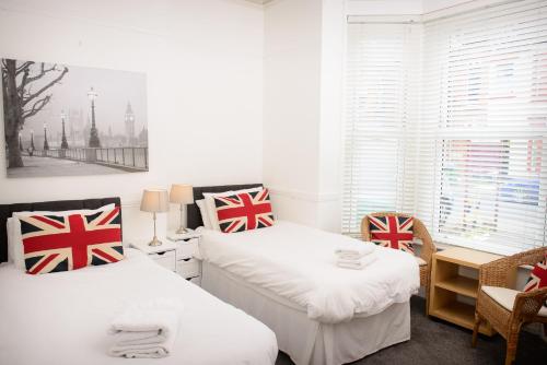 two beds in a room with british flag pillows at The Claremont in Southampton