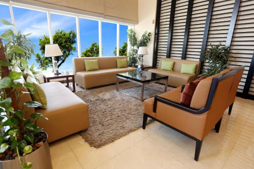 a living room with couches and tables and windows at V Hotel Fujairah in Fujairah