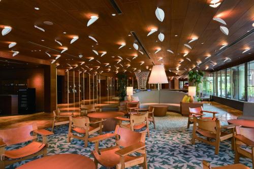 a lobby with tables and chairs in a hotel at Karuizawa Prince Hotel East in Karuizawa