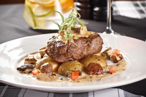 a plate of food with a piece of meat and potatoes at Hotel IOR in Poznań