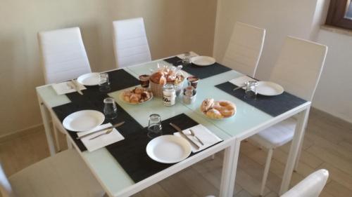 een eettafel met borden en eten erop bij Bonsai Bed & Breakfast in Fiumicino