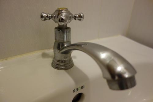 a bathroom sink with a silver faucet at Smile Society in Bangkok