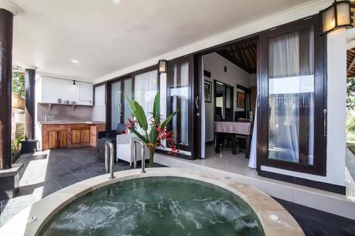 a jacuzzi tub in the middle of a house at Villa L'Orange Bali in Keramas
