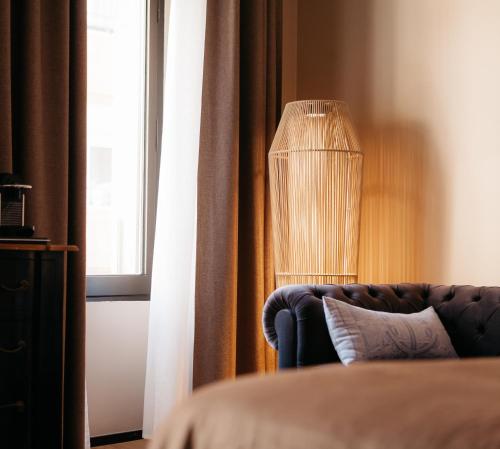 a room with a couch and a lamp next to a window at Hotel Casa Peya - Adults Only in Palafrugell