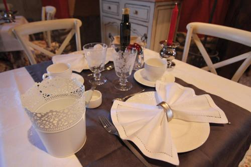 una mesa con placas blancas y un arco blanco en ella en Hotel Rural La Tenada en Carcedo de Burgos