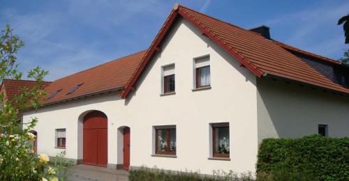 a white house with a red roof at Ferienwohnung Zschornack in Wittichenau