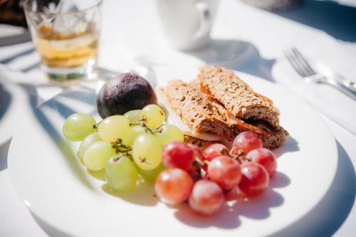 a plate of food with grapes and meat on a table at Hotel Casa Peya - Adults Only in Palafrugell