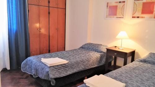 1 dormitorio con 2 camas y mesa con lámpara en Céntrico, Confortable y Cómodo en Córdoba