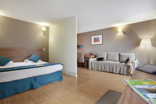 A bed or beds in a room at Odalys City Lyon Confluence