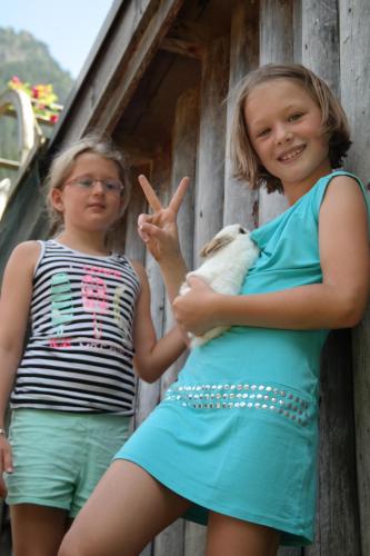 two girls standing next to each other holding a dog at Heisshof in Schladming