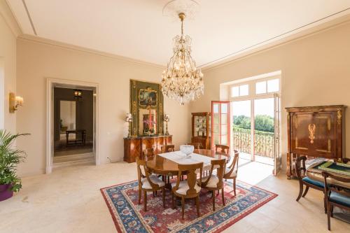 une salle à manger avec une table, des chaises et un lustre dans l'établissement Chambres d'hôtes de Château Renon, à Tabanac