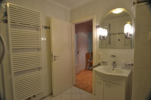 a white bathroom with a sink and a mirror at Schwarwald Apartment in Schluchsee