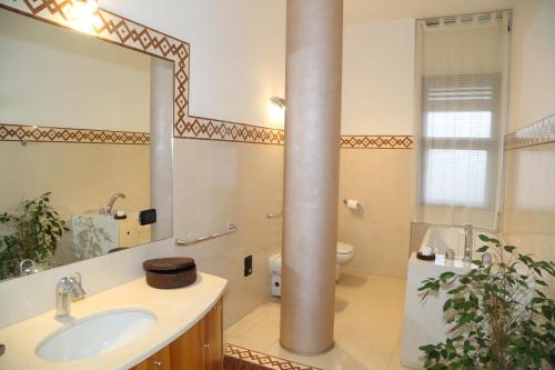 a bathroom with a sink and a toilet and a mirror at Bari Suite Apartment Leader Palace in Bari