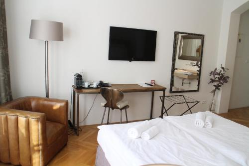 1 dormitorio con cama, silla y espejo en Jungmann Hotel en Praga
