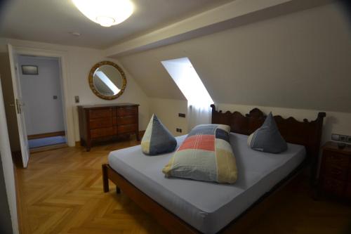 a bedroom with a bed with pillows and a mirror at Schwarwald Apartment in Schluchsee