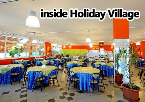 a restaurant with tables and chairs with blue table cloth at Don Antonio Glamping Village in Giulianova