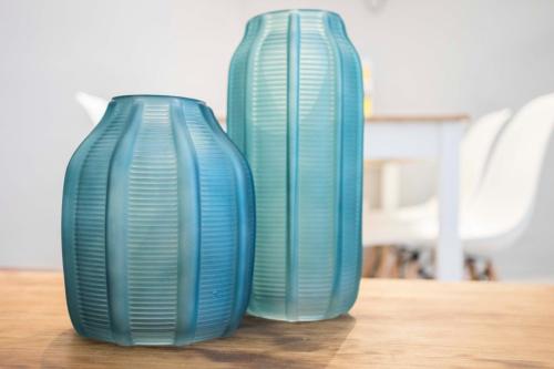 deux vases bleus assis au-dessus d'une table en bois dans l'établissement Total Valencia Vintage, à Valence