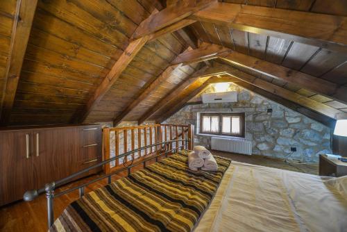 an attic room with a bed with two teddy bears on it at Abelos Villas in Áyios Ioánnis