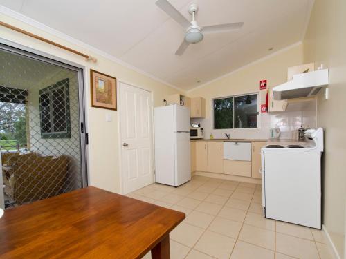 a kitchen with white appliances and a wooden table at Charleville Bush Cottage in Charleville