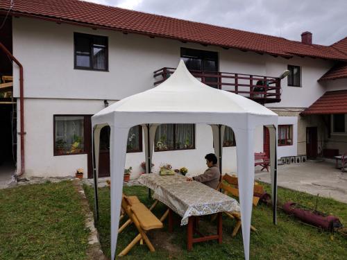 a woman sitting at a table under a white tent at Simon House in Şimon