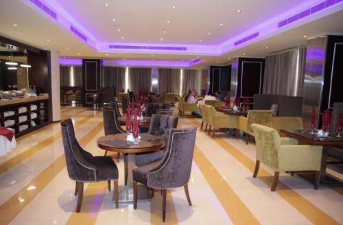 Dalin Hotel في الرياض: مطعم بطاولات وكراسي وبار