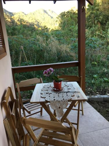 ein Tisch und zwei Stühle auf einer Veranda mit einem Tisch und Blumen in der Unterkunft Cantinho da Paz in São Pedro da Serra