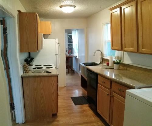 cocina con armarios de madera y nevera blanca en Cute Smarthouse Granite Close to Lake, en Klamath Falls