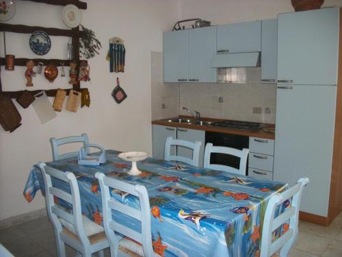サン・テオドーロにあるCasa Tavolaraのテーブルと椅子、テーブル、キッチン付きのキッチン