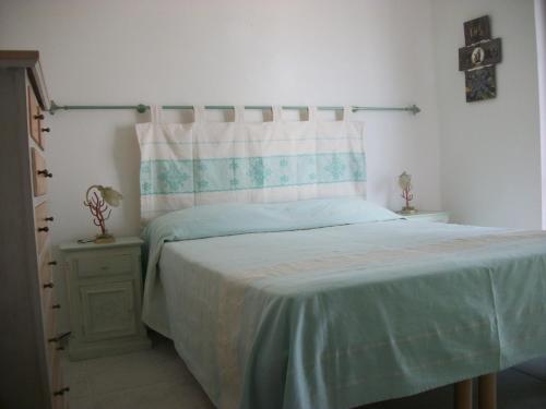 サン・テオドーロにあるCasa Tavolaraのベッドルーム1室(青い毛布付きのベッド1台付)