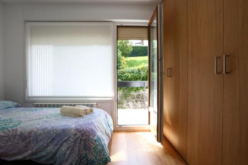 オンダリビアにあるHiger Bidea 1 - Basquenjoyのベッドルーム1室(ベッド1台付)、スライド式ガラスドアが備わります。