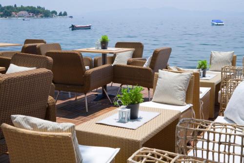 Hotel Minelska Resort في بلاك كالا: صف من الطاولات والكراسي على سطح بجانب الماء