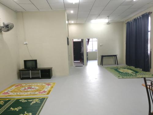 une chambre avec 2 tapis au sol et une télévision dans l'établissement Arau Guest House, à Arau