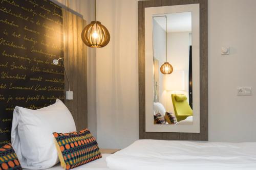 a bedroom with a bed and a mirror at Landgoed ISVW in Leusden