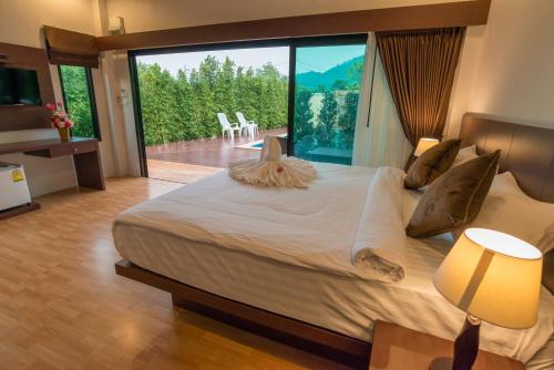 a bedroom with a large bed with a large window at Aonang Glory Resort in Ao Nang Beach