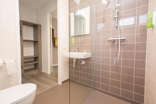 a bathroom with a shower and a sink and a toilet at Landgoed ISVW in Leusden