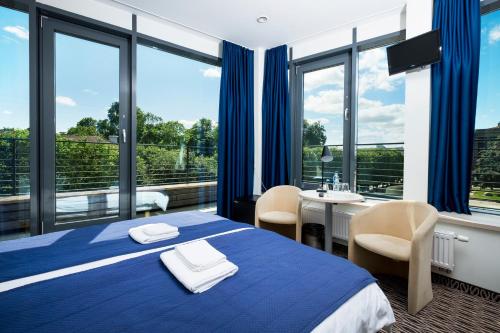 a hotel room with a blue bed and a balcony at Kaunas City in Kaunas