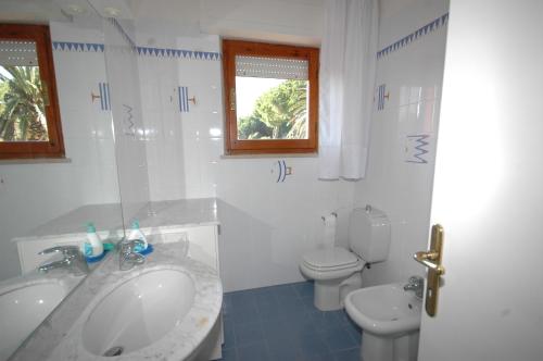 マリーナ・ディ・カンポにあるCameliaの白いバスルーム(洗面台、トイレ付)