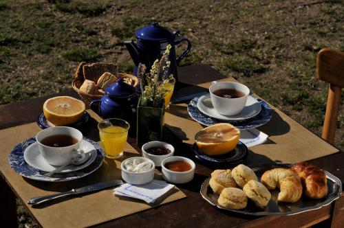 a table with cups of coffee and pastries on it at LAS JARILLAS Hostería & Bodega in San Javier