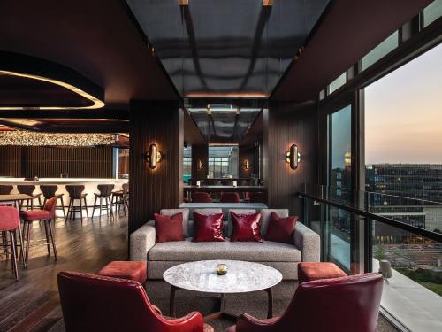 a living room with a couch and a table and chairs at Cordis Shanghai Hongqiao (Langham Hospitality Group) in Shanghai